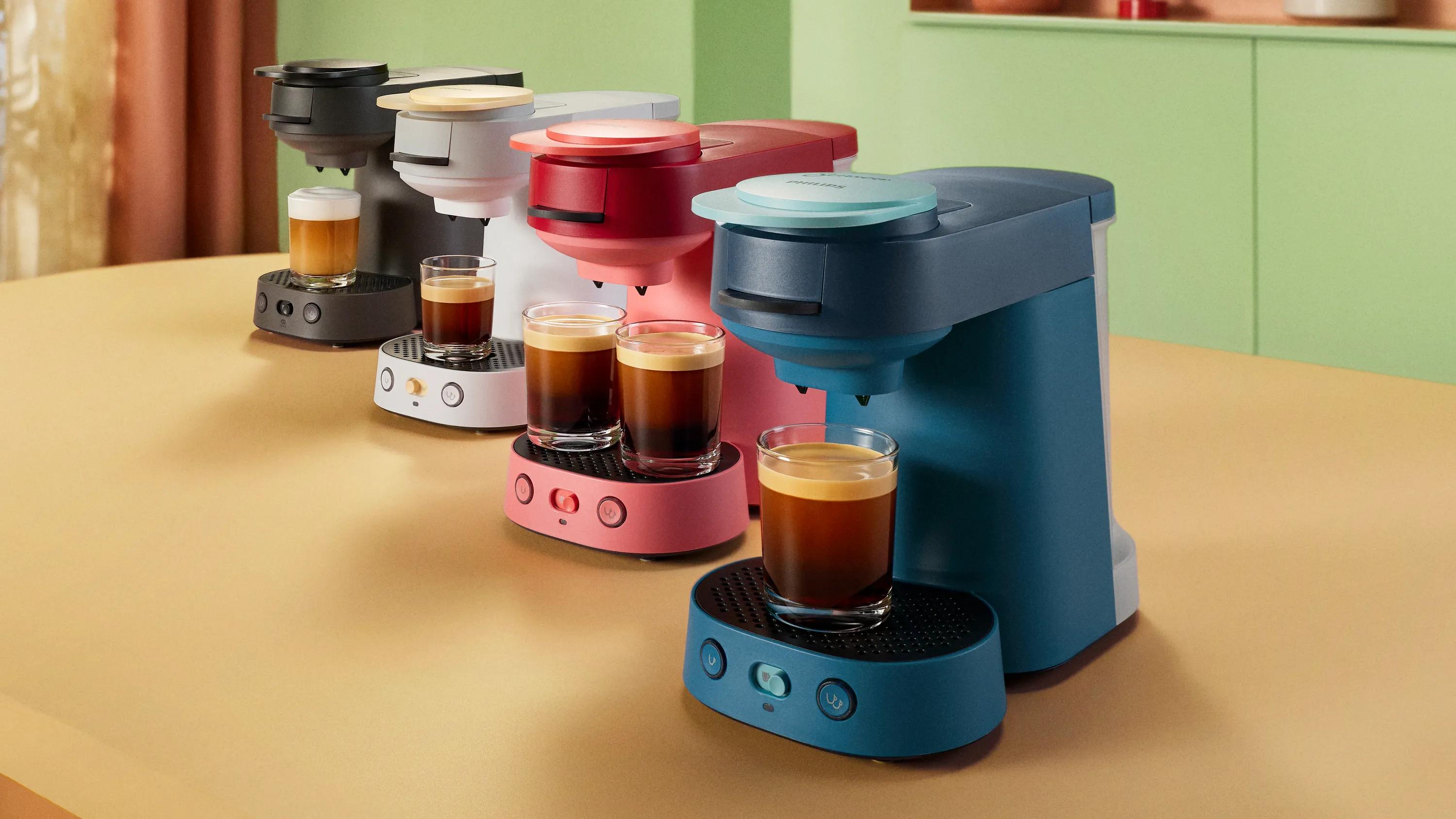 Zwarte, witte, roze en turquoise Philips SENSEO® Vibe machines samen gerangschikt op een aanrecht.