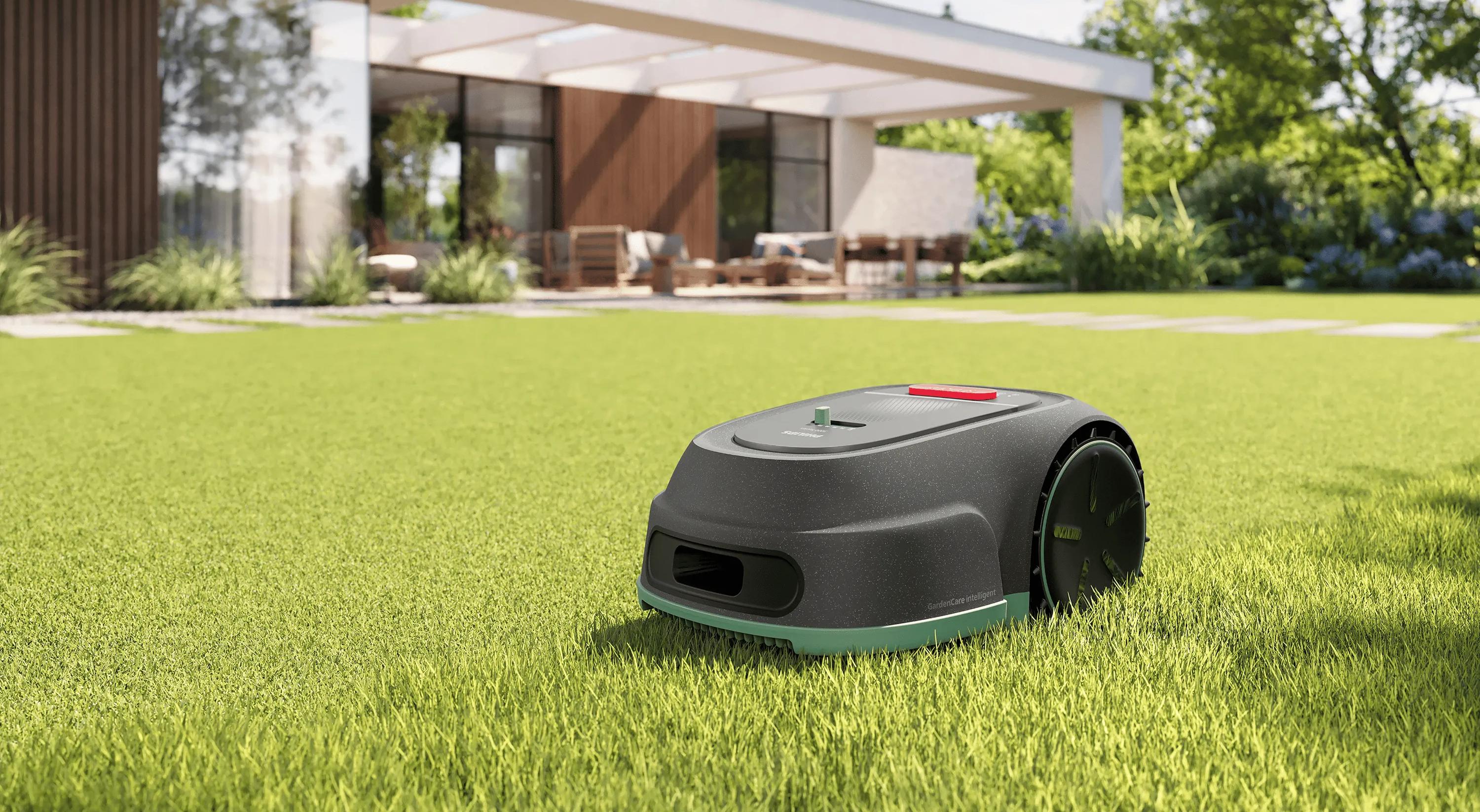 Philips automatischer Rasenmäher mäht Gras in einem modernen Garten mit Smart-Home-Terrasse im Hintergrund – intelligenter Mähroboter für mühelose Rasenpflege.