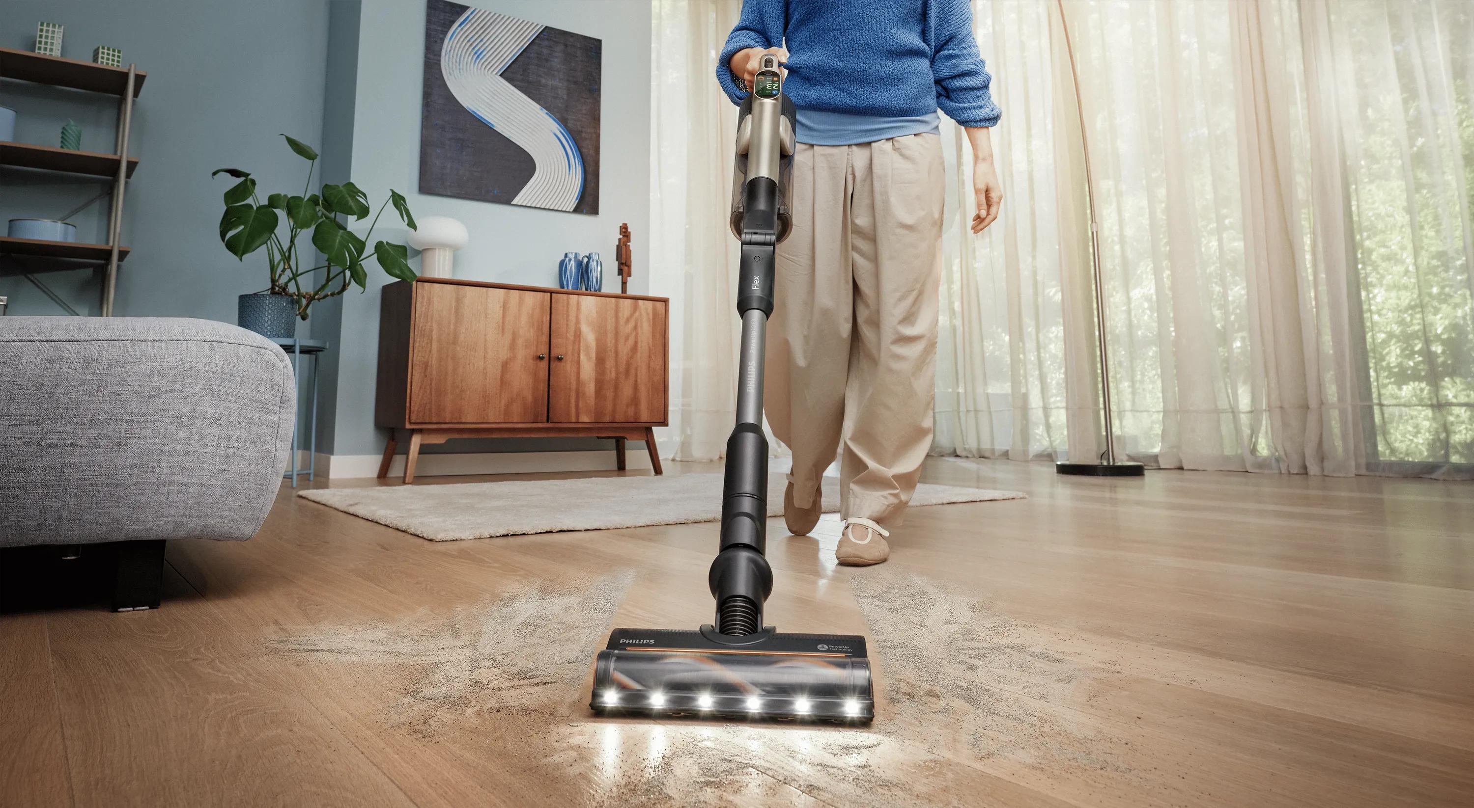 Philips PowerUp snoerloze stofzuiger die stof en vuil van een harde vloer verwijdert, met heldere LED-lampjes die verborgen vuil zichtbaar maken.