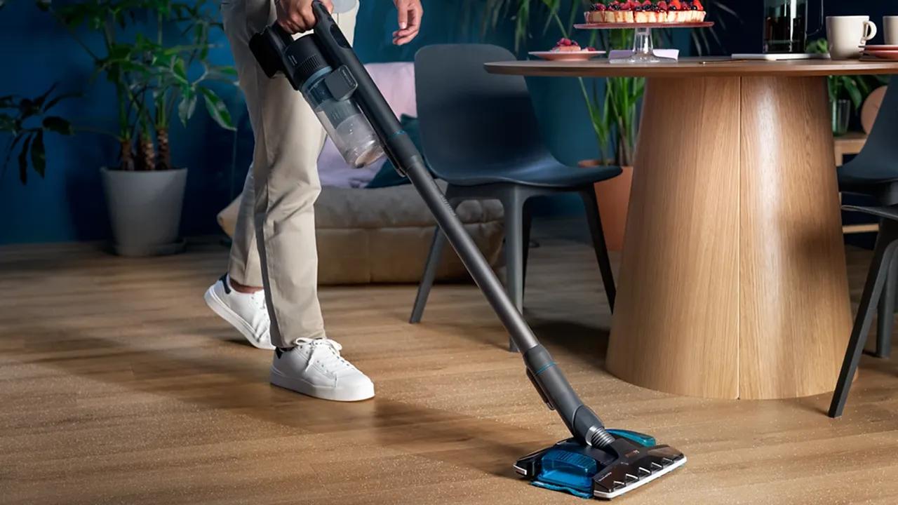 Philips Aqua Plus 8000: En sladdlös skaftdammsugare med avancerade funktioner för överlägsen golvrengöring och enkel moppning, sedd städa ett stilfullt vardagsrum.