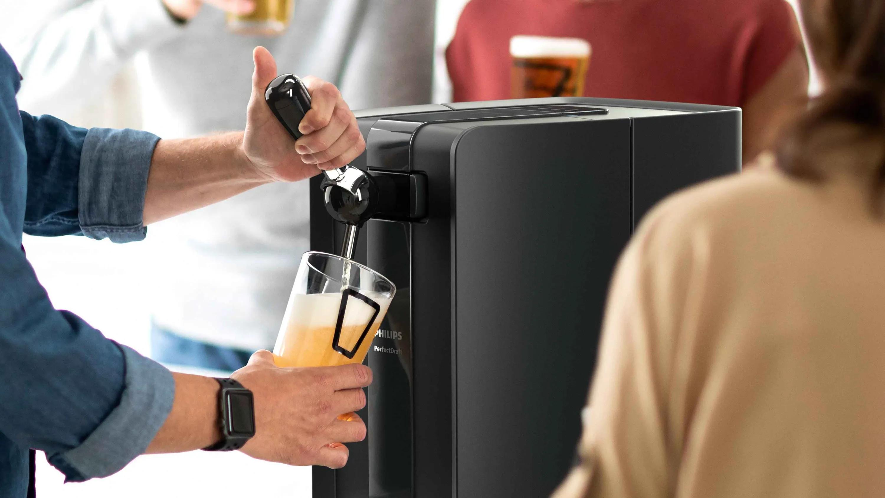Close-up of a Philips Perfect Draft beer dispenser pouring a pint, showcasing its advanced technology for perfectly chilled and carbonated beer at home.